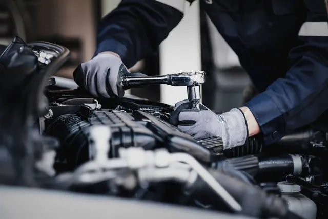 A mechanic inspecting a vehicle in a repair workshop